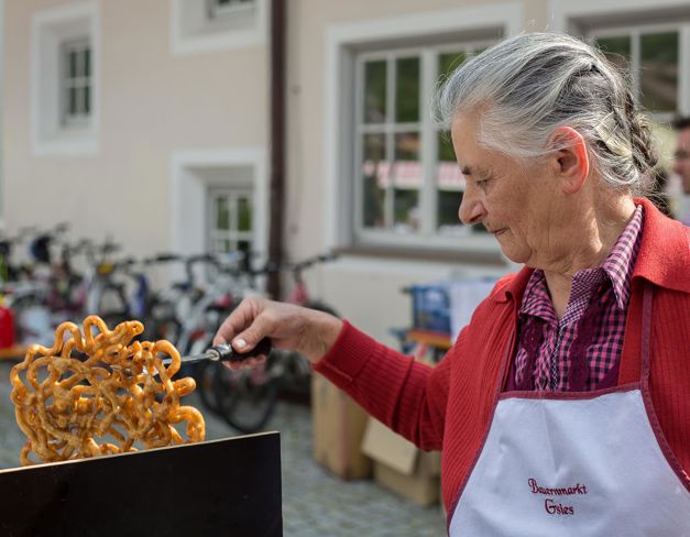 Eine Bäuerin backt Strauben