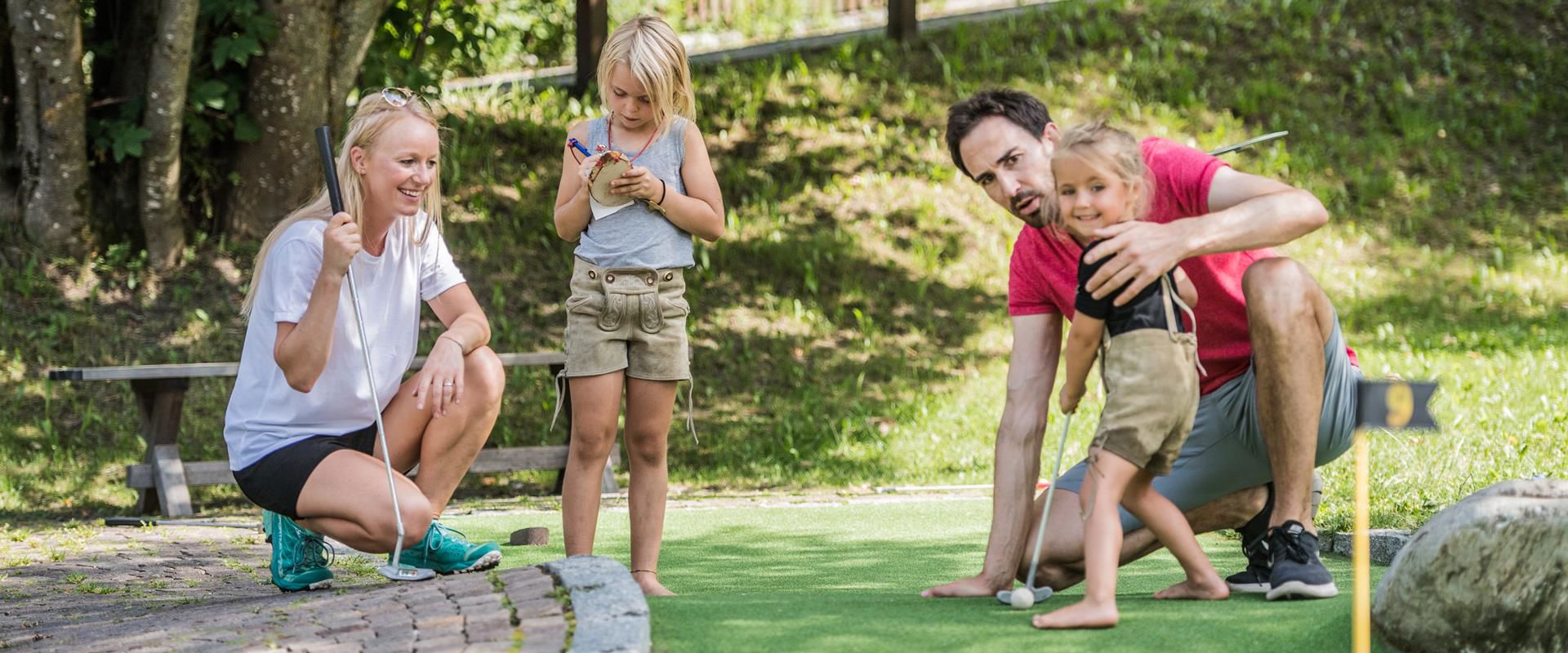 Eine Familie spielt Minigolf