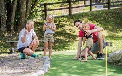 Eine Familie spielt Minigolf
